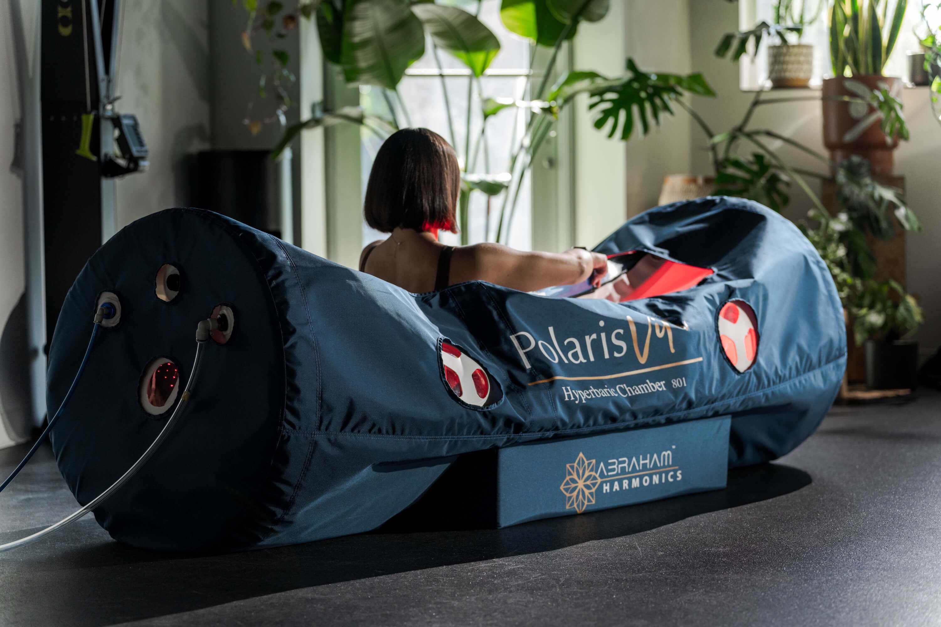 Client Receiving Hyperbaric Oxygen Therapy Inside A Soft Shell Chamber At A Wellness Clinic